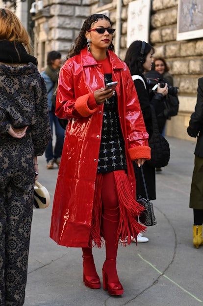 PARIS, FRANCE - SEPTEMBER 30: A guest is seen wearing a red coat, black and pearl embroidered dress,...