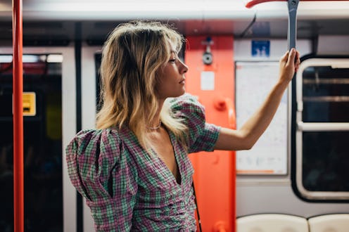 A side view of a pensive Caucasian female using public transport. (bus)