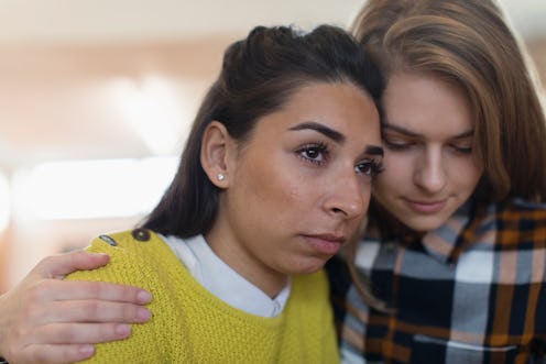 Close up young woman consoling sad, crying friend