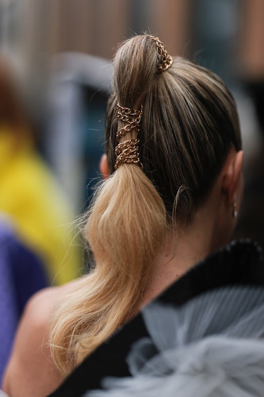 A fashion week guest with a statement ponytail, the 2022 holiday beauty trend for Sagittarius