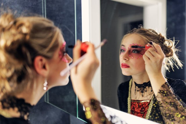 Teenage girl is painting her face for Halloween in bathroom.
Shot with Canon R5