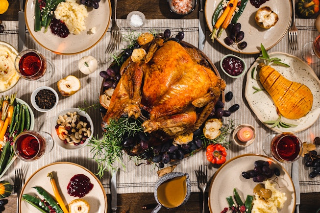 Directly above view of a traditional Thanksgiving meal with roasted turkey on the dinner table. Roas...