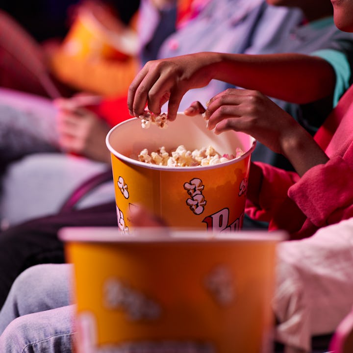 child eating popcorn in theater. a mom just took to reddit to see if she was in the wrong for handin...