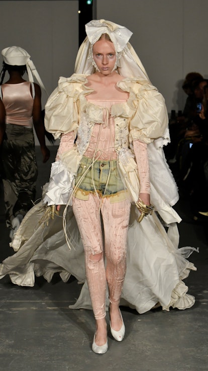 Weirdest Paris Fashion Week 2022 looks: A model wear denim shorts and a Marie Antoinette style top d...