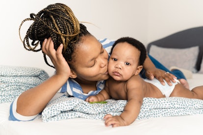 Portrait of a happy African American woman playing with her cute baby boy in article on Instagram ca...