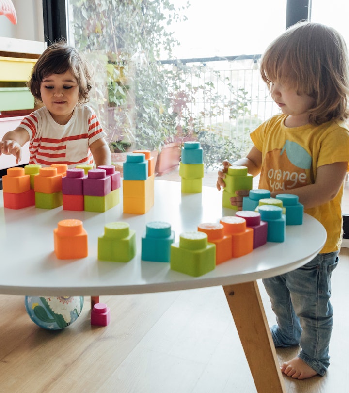 2-year-old little boy and girl playing with colorful plastic toy blocks