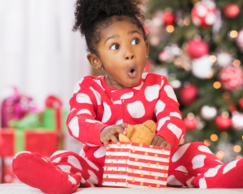 excited and happy child unwrapping holiday present from amazon's top toys list of 2022