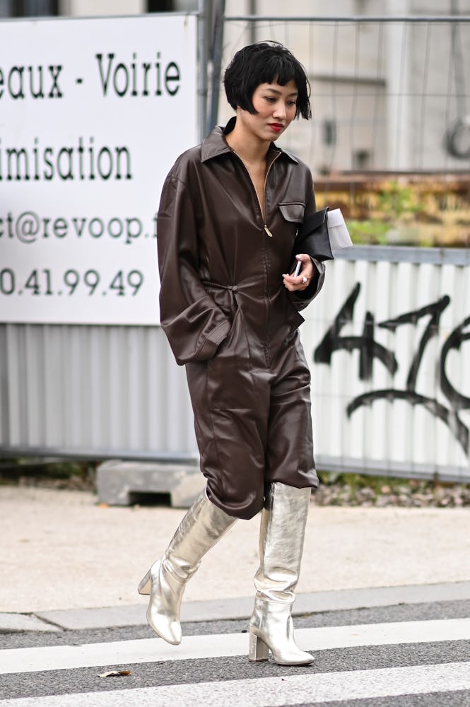A guest is seen wearing a brown leather jumpsuit and gold boots