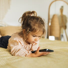 Child watching cartoons on mobile phone. Leisure at home.  Digital native. Child using smartphone.