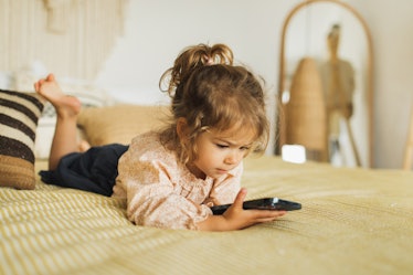 Child watching cartoons on mobile phone. Leisure at home.  Digital native. Child using smartphone.
