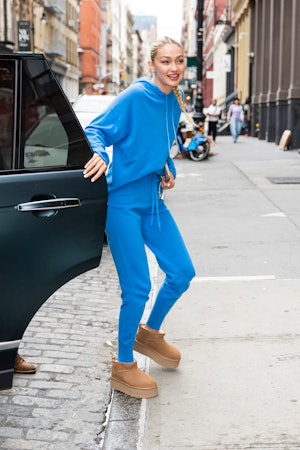 ジジ・ハディッドはブルーのスウェットパンツとプラットフォームのアグのブーツを履いている。