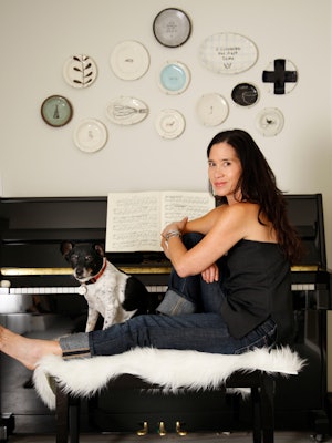 Illustrator Rae Dunn and her dog Wilma sit at the piano in the studio at home.