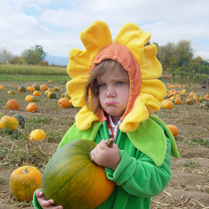 Kid pouting at pumpkin patch
