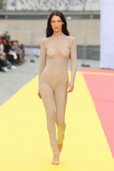 Bella Hadid wearing Stella McCartney transparent maxi nude studded jumpsuit at Paris Fashion Week Sp...