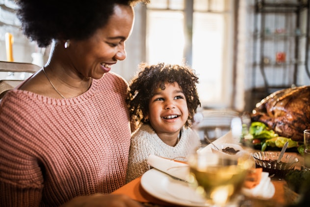 Happy mother enjoying with her daughter during Thanksgiving meal at dining table. in a round up of T...