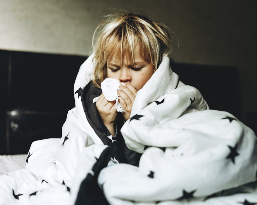 Toddler boy in bed with runny nose, a sign of RSV in toddlers