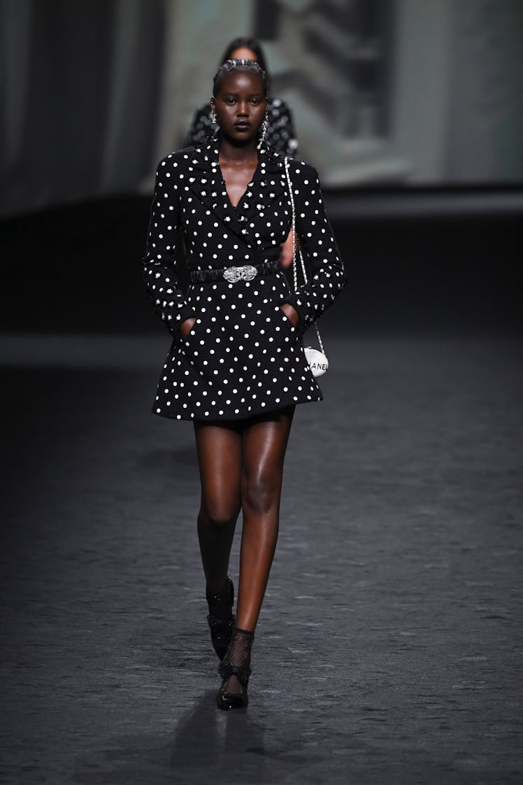 A model in Chanel polka black-white long sleeve dress with belt at Paris Fashion Week Spring 2023