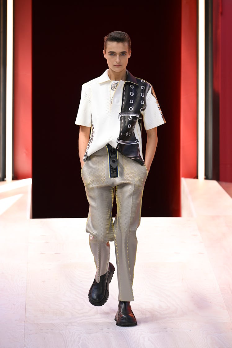 Male model wearing a Louis Vuitton black and white t-shirt and gray pants at Paris Fashion Week Spri...