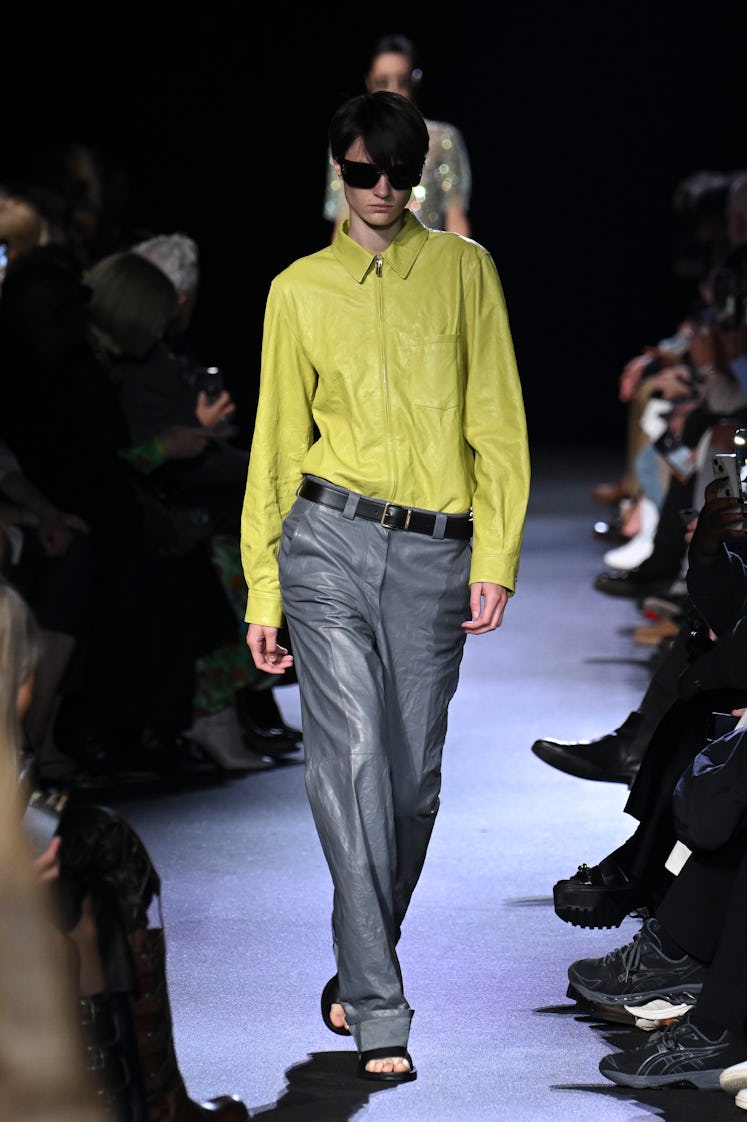 Male model wearing Miu Miu bright yellow leather shirt and gray leather at Paris Fashion Week Spring...