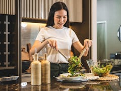 A woman learns how to make the pizza salad from TikTok at home.