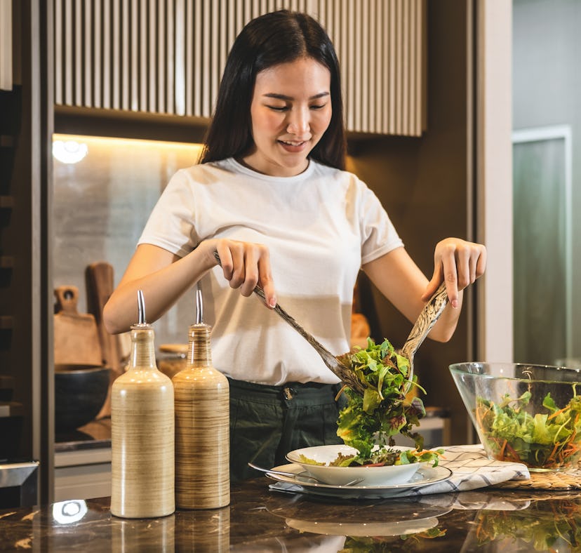 A woman learns how to make the pizza salad from TikTok at home.