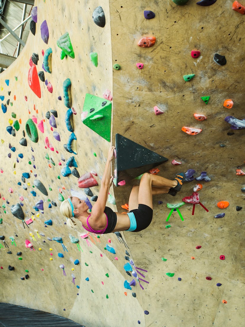 Ascending an indoor rock climbing wall works your forearms, biceps, and triceps.