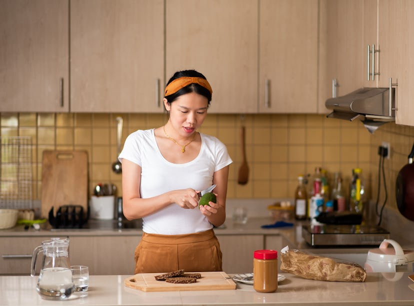 A woman making one of the peanut butter boards on TikTok in her kitchen. 