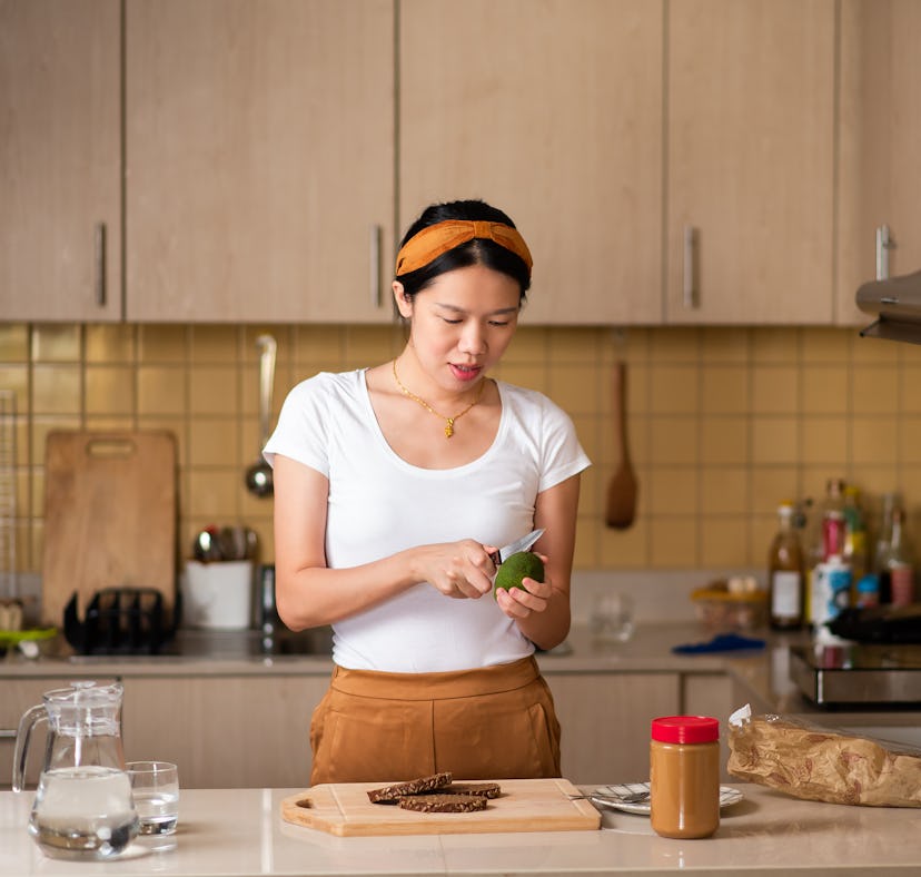 A woman making one of the peanut butter boards on TikTok in her kitchen.