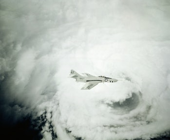 AU.S. Navy F9F-8P Gruman photographic plane flies above the eye of hurricane Gracie flying around th...