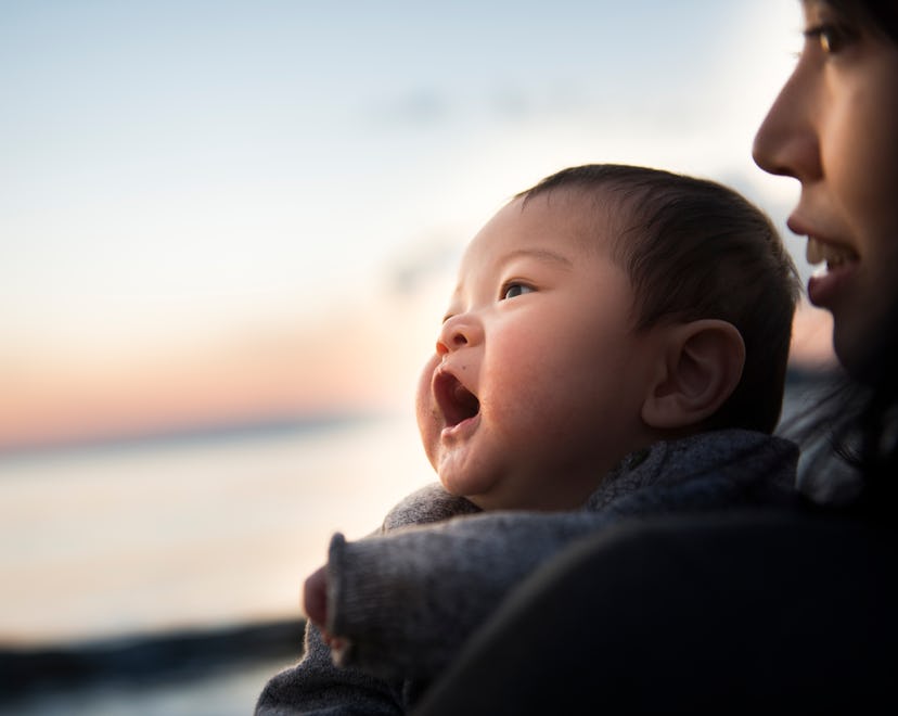 A Baby and Mother in the sunset ocean.