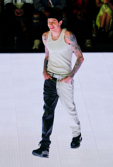 Pete Davidson Style Evolution: Davidson wore two-toned pants and tank top at the runway at Alexander...