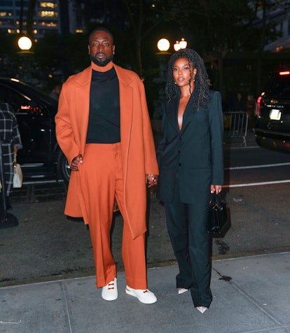 Gabrielle Union and Dwyane Wade wearing matching pantsuit outfits.