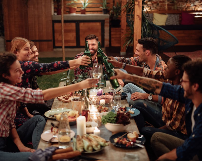 Happy diverse friends toasting at friendsgiving dinner party
