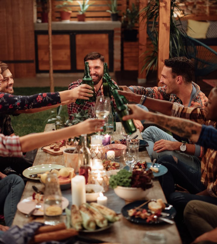 Happy diverse friends toasting at friendsgiving dinner party