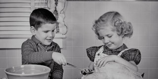 1950s SMILING BOY AND GIRL BROTHER AND OLDER SISTER LADLING BREAD STUFFING INTO THANKSGIVING TURKEY ...