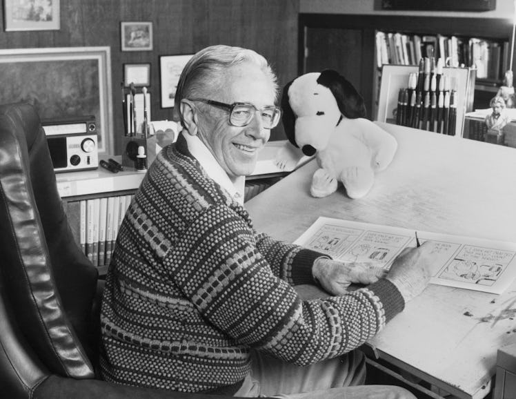 Cartoonist Charles M. Schulz, creator of the "Peanuts" comic strip, draws in his studio near a stuff...