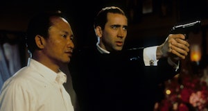 Director John Woo watches as Nicolas Cage aims pistol in between scenes from the film 'Face/Off', 19...