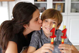 Teen girl kissing brother at birthday celebration