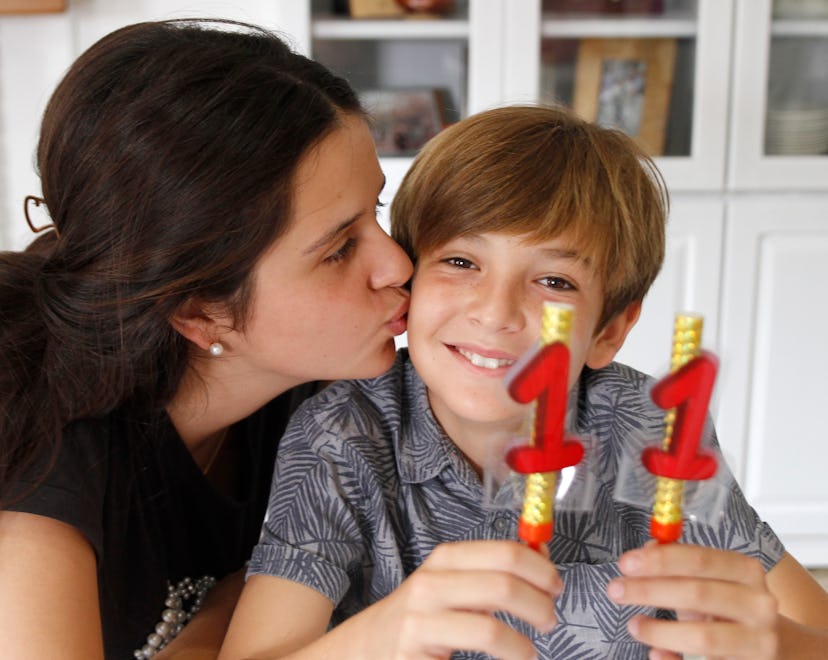 Teen girl kissing brother at birthday celebration