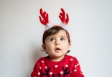 Adorable baby wearing christmas reindeer antlers, superstitions about christmas babies