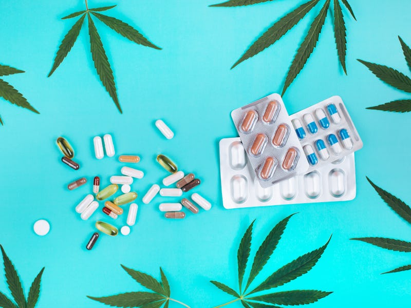 Set of pills and blister packs with tablets made of cannabis on turquoise background with cannabis l...