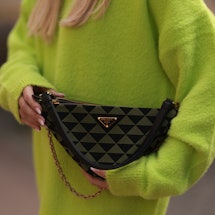 Sonia Lyson, bag detail, wearing Prada triangle olive black bag, Storets neon green oversized sweate...