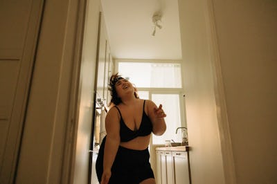 young woman dances in her apartment as she considers how jupiter retrograde 2022 ending will affect ...