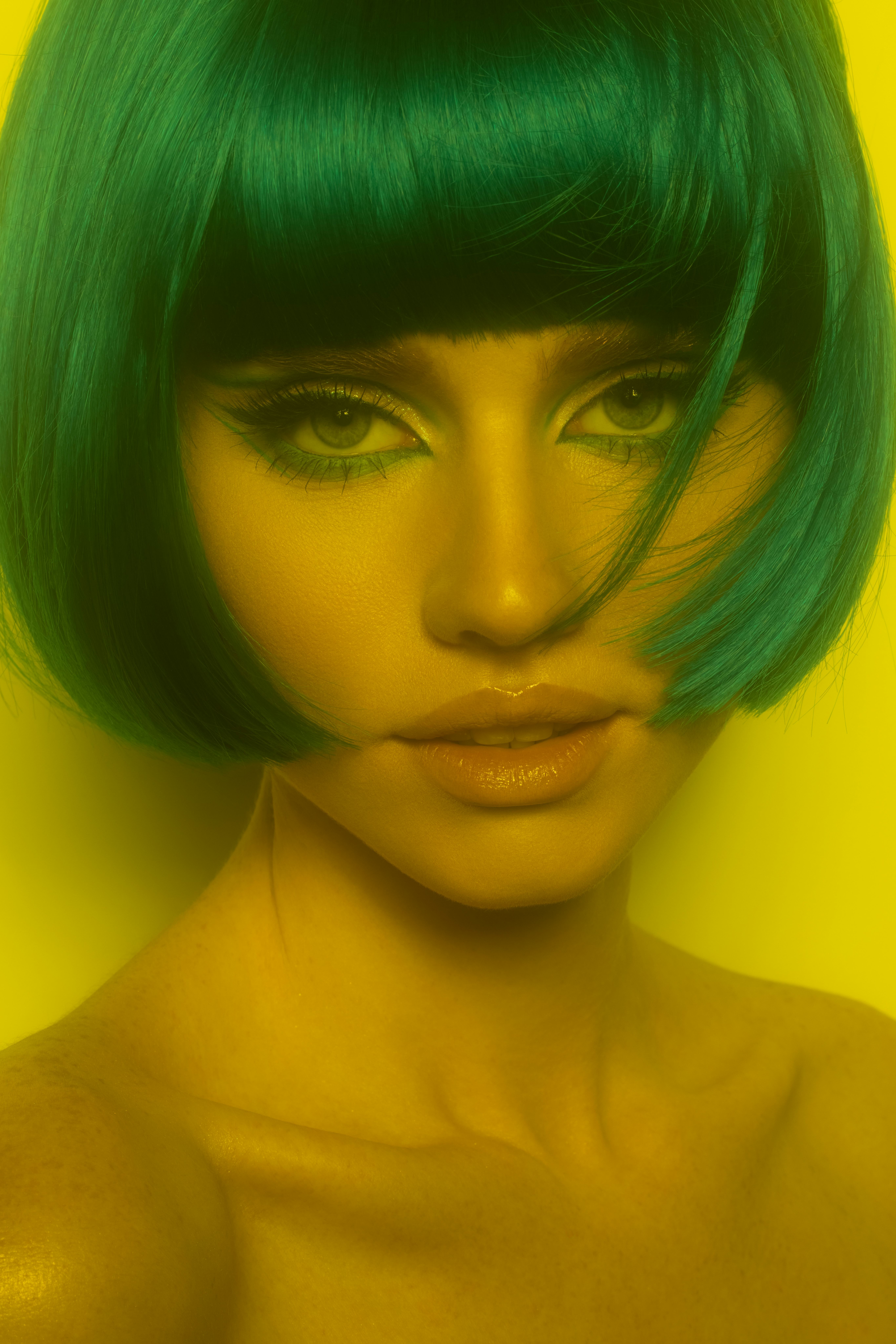 The 2023 haircut trend for Cancer is a chin-length bob as seen on a young woman with green hair.