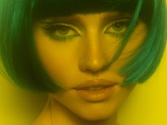 The 2023 haircut trend for Cancer is a chin-length bob as seen on a young woman with green hair.
