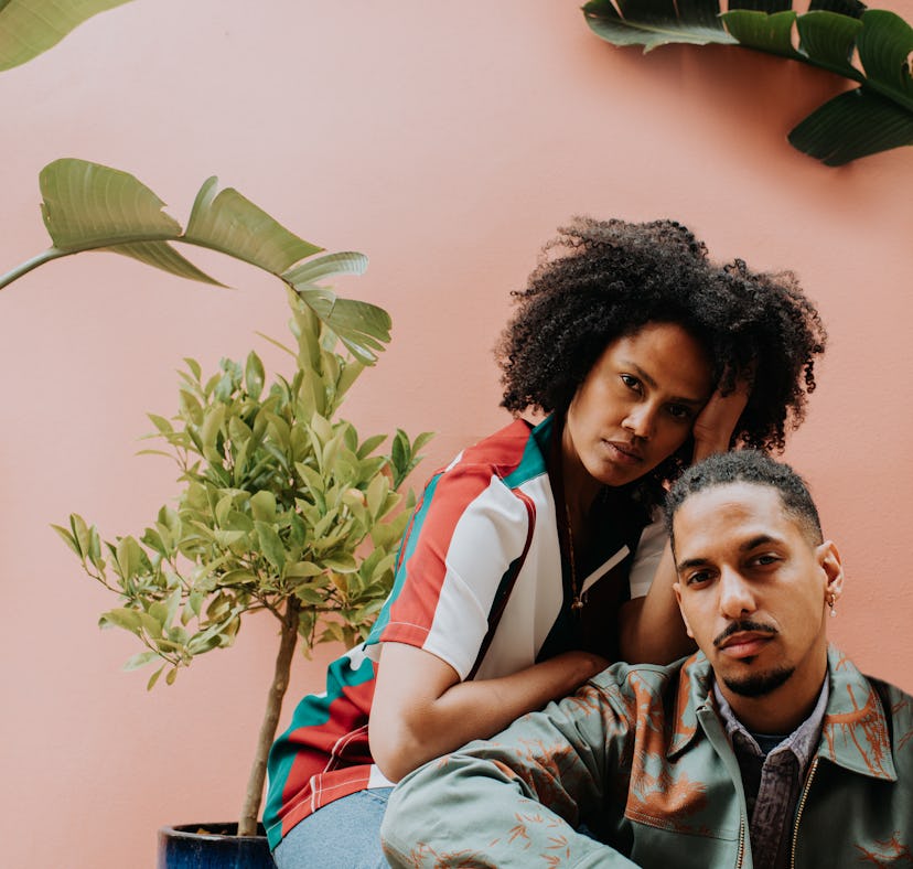 two friends lean comfortably on each other as they discuss their november 28, 2022 weekly horoscope