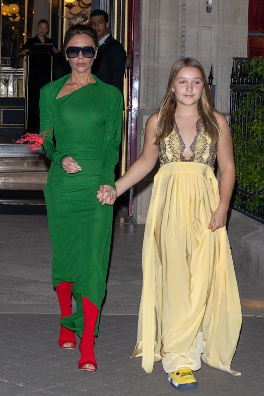 Victoria Beckham wearing a red and gold feather brooch.