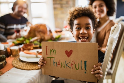 girl looking at the camera during thanksgiving dinner with her parents, in thanksgiving...