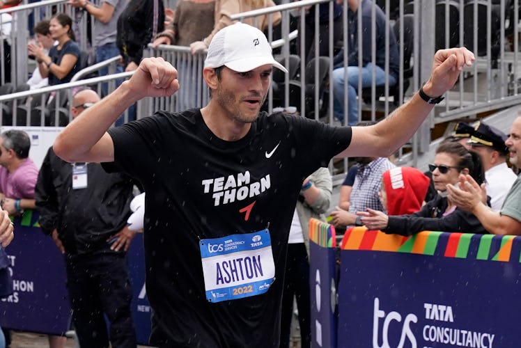 Ashton Kutcher celebrates while crossing the finish line during the 2022 New York City Marathon in N...