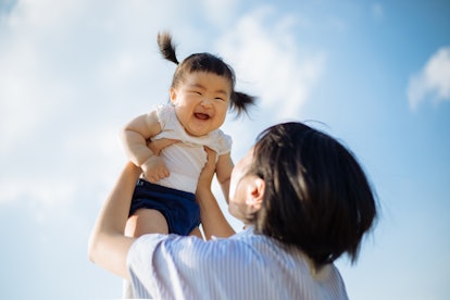 baby girl against a blue sky with her mom, giggling, in a list of baby names that mean blue